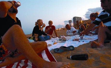 Un grupo de jóvenes cena y consume alcohol en la Barceloneta, la semana pasada.