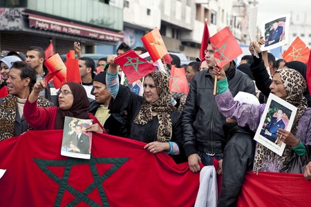 Miles de marroquís enarbolan banderas y portan retratos del rey Mohamed VI, que han acudido a la manifestación convocada hoy en Casablanca por sindicatos y partidos políticos marroquís para protestar en contra de la política del PP hacia Marruecos.