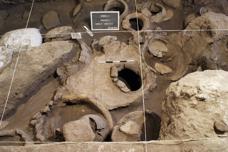 Una prensa de vino, detrás de la cual los arqueólogos han puesto elementos de identificación, y a la derecha, un recipiente para la fermentación de la uva, hallados en una cueva de Armenia, una imagen facilitada por 'National Geographic'. 