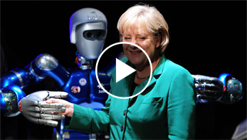 La cancillera Angela Merkel bromea junto a un robot en la Exhibición Internacional Espacial.