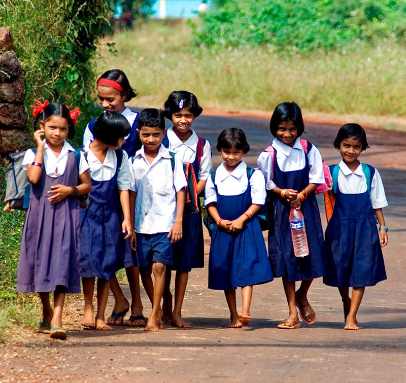 Nens de camí a l'escola en una carretera de l'Índia.